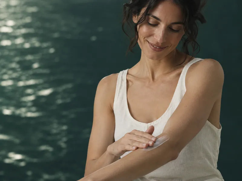 AI-generated editorial portrait of an adult woman applying body lotion to her forearm